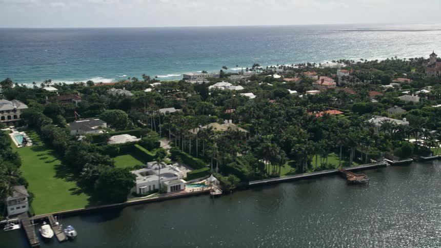 An aerial view of upscale waterfront mansions with docks along the Palm Beach coastline in sunny Florida
