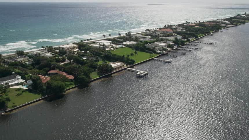 Aerial footage of waterfront mansions with docks passing by on Lake Worth in Palm Beach Florida