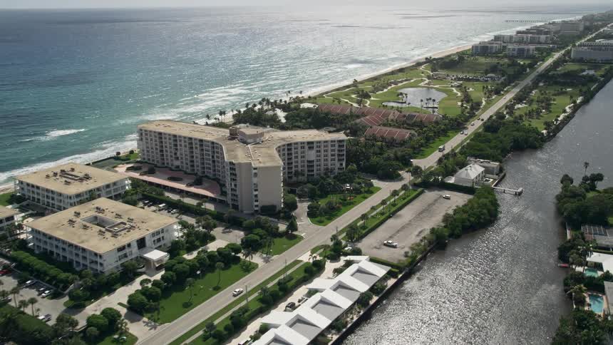 Aerial view of oceanfront condominiums and golf course in Palm Beach Florida on a partly cloudy day