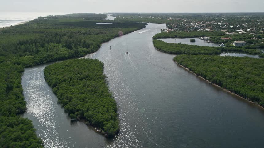 Approaching and flying over sailboats on the sunny Indian River through Hobe Sound Florida