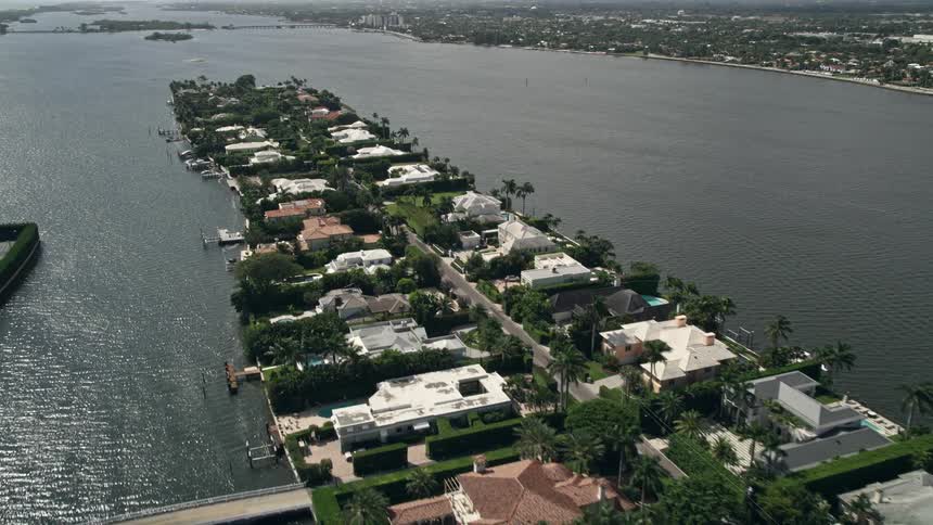 An aerial view of luxurious lakefront mansions in Palm Beach during the day