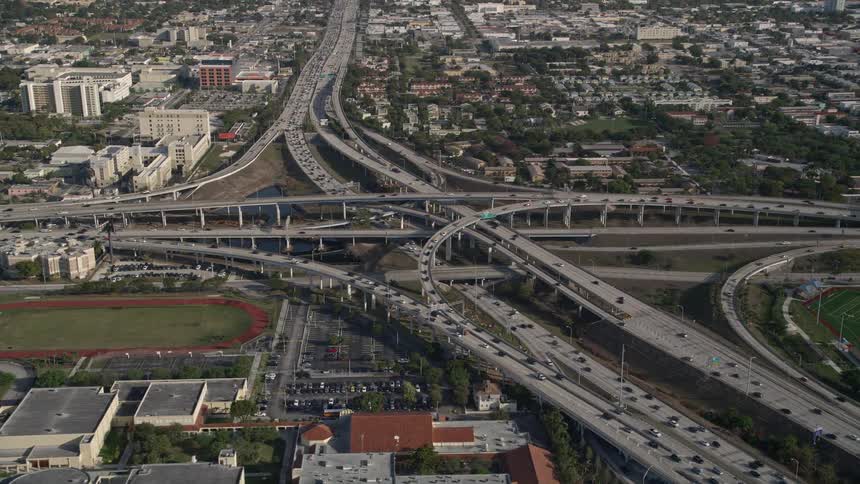 Traffic passing through the intersection of Interstate 95 and Highway 836 near Booker T Washington High School in Overtown Florida captured in 5K aerial footage