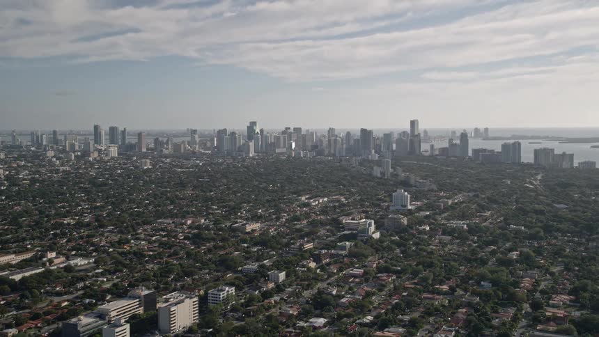 An aerial flyover of suburban neighborhoods leading up to the reveal of Downtown Miami skyline and Coconut Grove in Florida