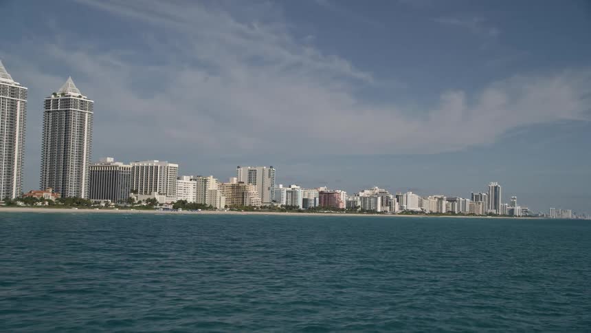 Flying over Miami Beachs Blue and Green Diamonds hotels and apartments capturing stunning views of the seaside high rises and beachgoers enjoying their recreation in the sunshine