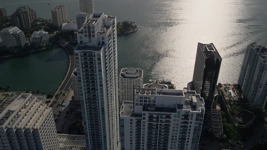 Aerial footage of orbiting the Plaza on Brickell Tower 1 in Downtown Miami FL capturing the high rise towers and modern buildings in the metropolitan area