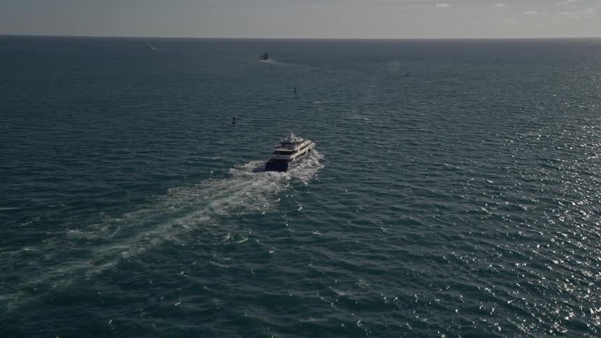 A yacht sails across the Atlantic Ocean in Miami Florida captured in aerial footage