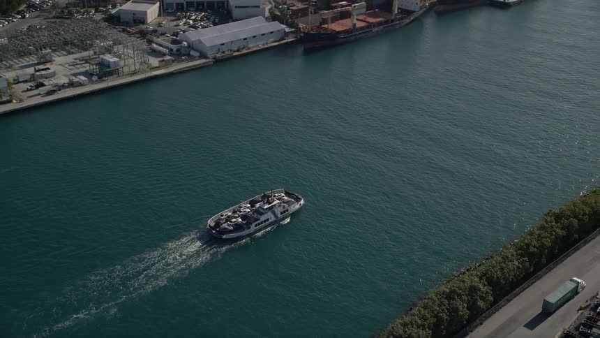 Aerial tracking footage of a ferry sailing through Government Cut in Miami Beach Florida on a sunny day