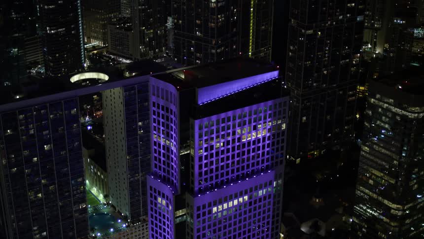 Approaching Brickell World Plazas illuminated rooftop in downtown Miami revealing the stunning backdrop of the citys skyline at night