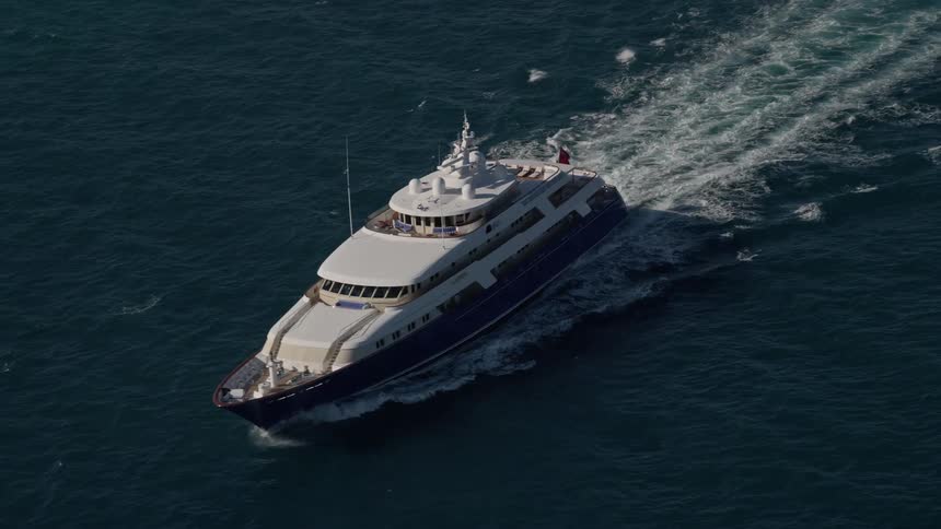 A yacht boat sails through the Atlantic Ocean in Miami Florida captured using a drone in 5k aerial footage