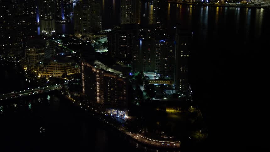 Approaching the luxurious Mandarin Oriental Hotel on Brickell Key the camera captures the clear night skyline of downtown Miami with its towering high rises