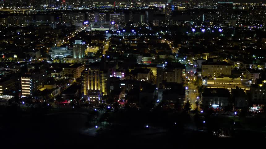 A breathtaking aerial view passing by hotels and Ocean Drive at night in South Beach Florida