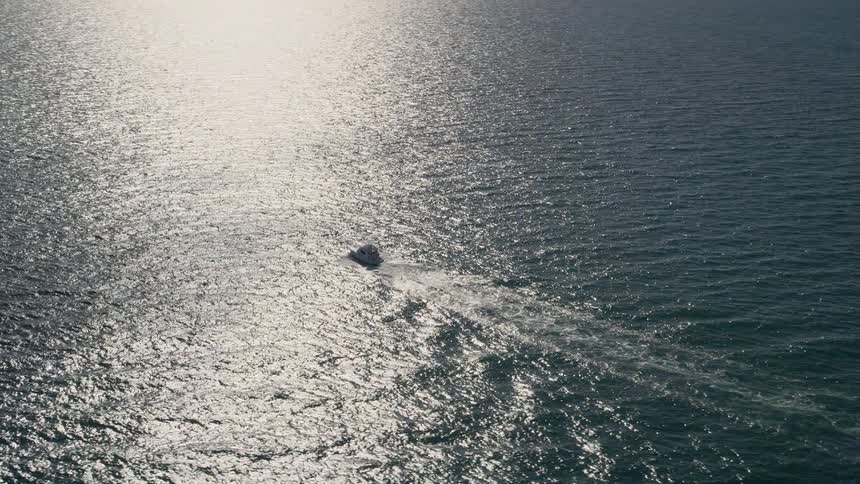 A stunning aerial view of a fishing boat cruising through the Atlantic Ocean off the coast of Miami Florida
