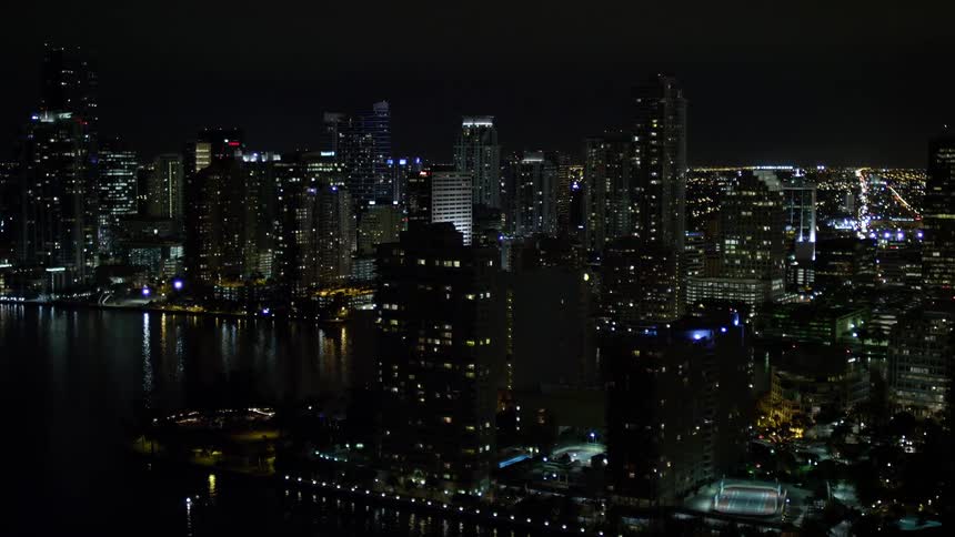 The camera captures an aerial flyby of skyscrapers on Brickell Key in Downtown Miami at night