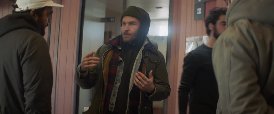 A man is giving direction to someone in the hall