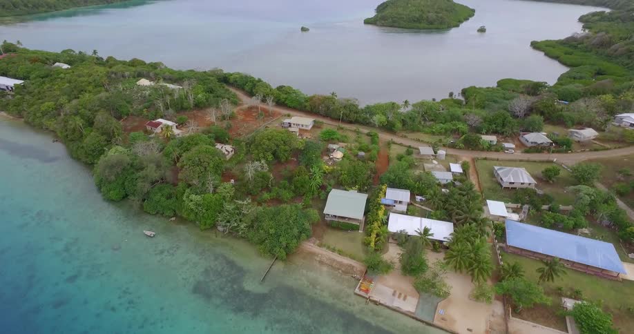A small island with houses and trees on it in a body of water