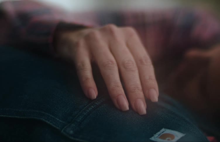 A woman runs her hand down her partners chest