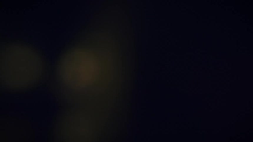 Different colored spots of light blur across darkness