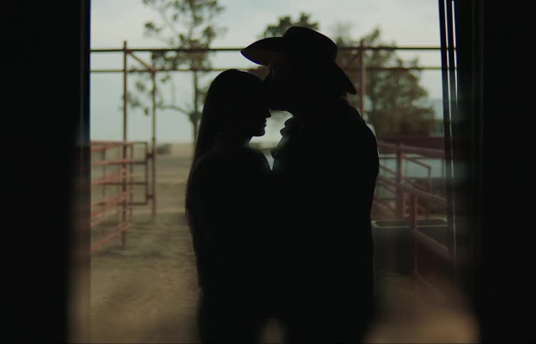 Silhouette of a couple kissing lovingly in a doorway