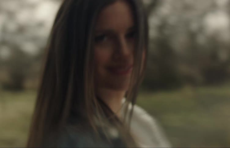 A woman spins back and forth in a field