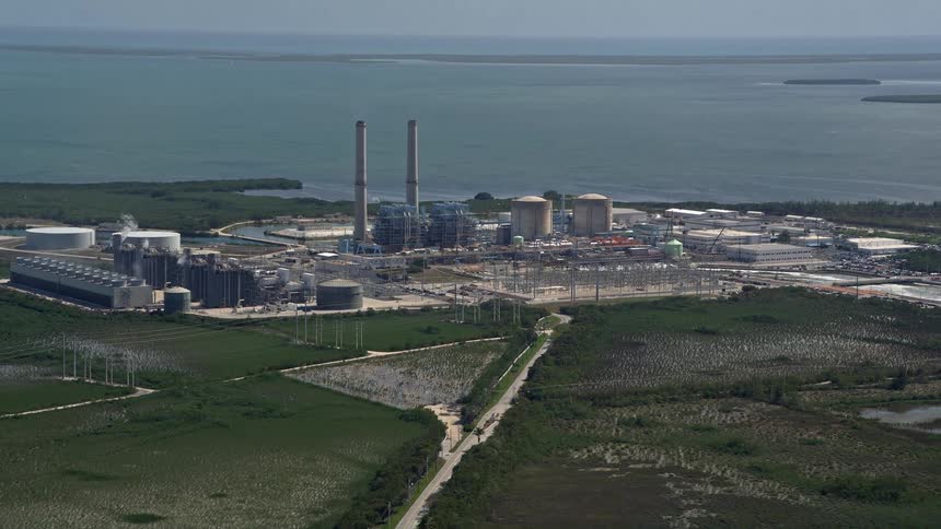 Flying over Turkey Point Power Plant Homestead in Florida on a sunny day showcasing the power stations two chimneys and its contribution to energy and fuel production on the Florida coastline