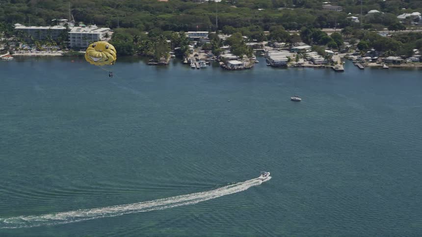 Parasailers being pulled by a speedboat over Blackwater Sound in Key Largo Florida during summertime