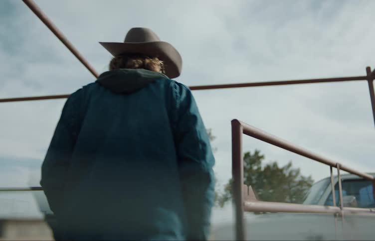 A man walks through his ranch to his pickup truck