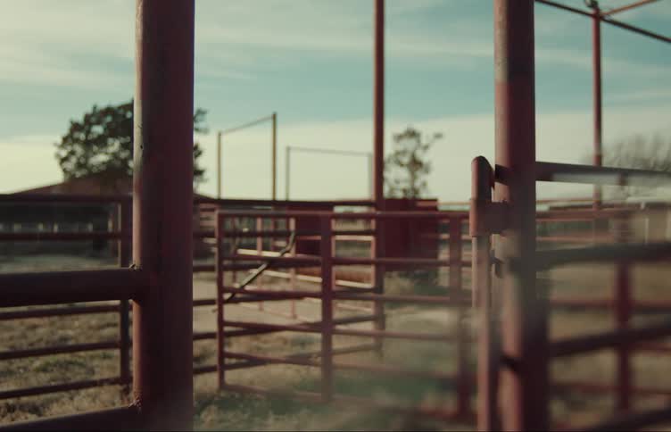 An opened gate to an empty corral