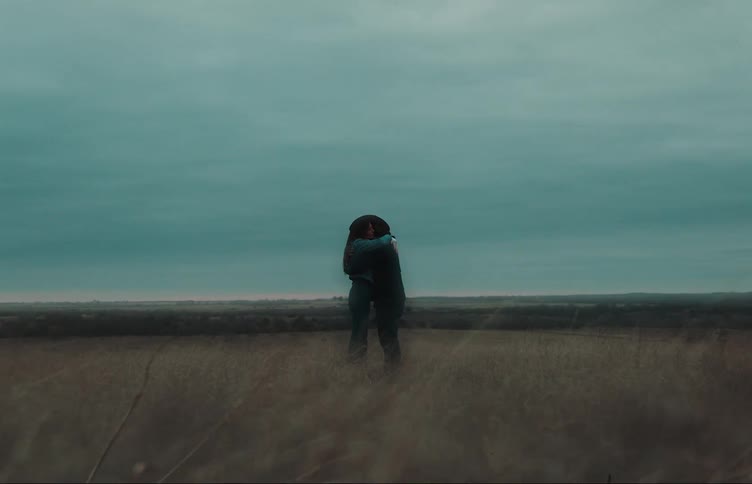 A man and woman hug on the field