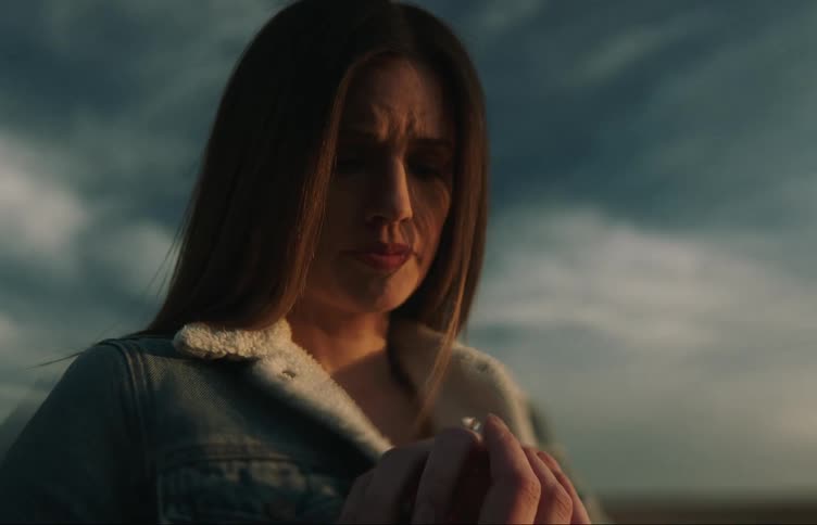 A woman is examining a diamond ring on her hand