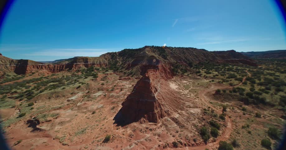A camera mounted on a drone flies very rapidly around a canyon