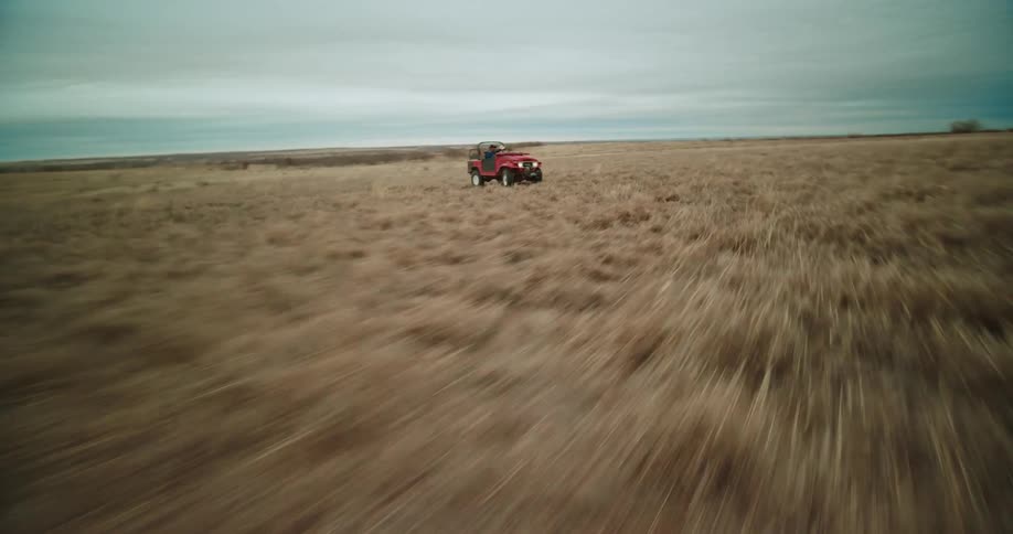 A jeep speeds through an open field