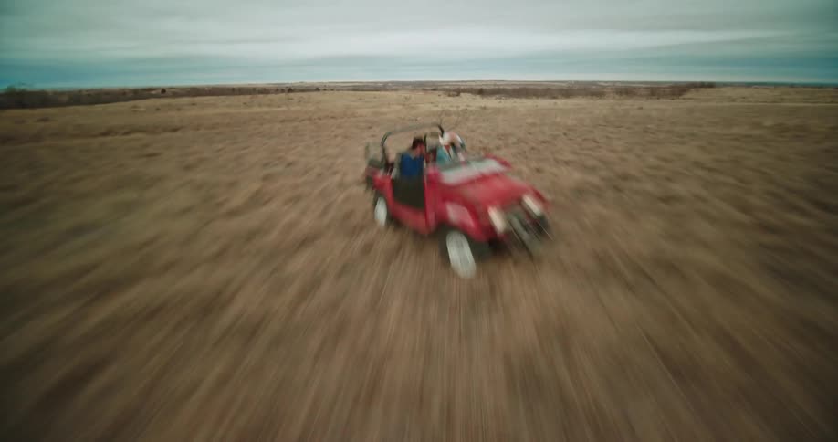 A person is driving a vehicle off road in a desert area