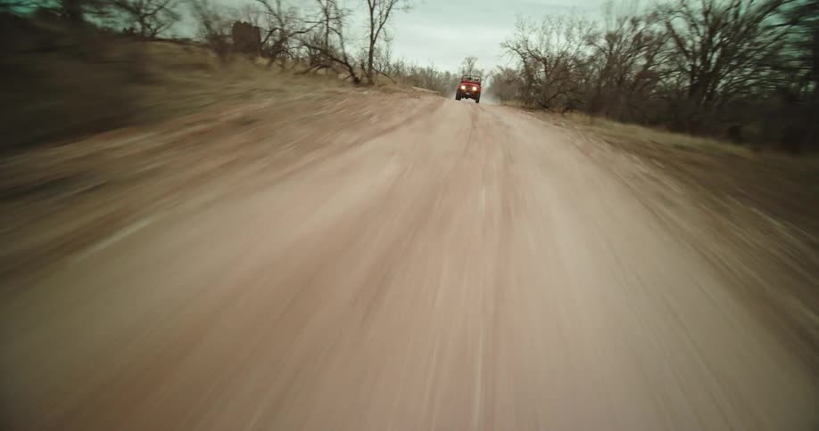 Speeding on a dirt road until revealing a jeep and going over it