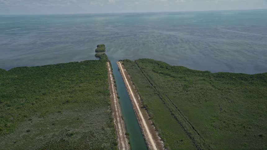 An aerial view of a canal flowing through the mangroves and into the Atlantic ocean in Homestead Florida