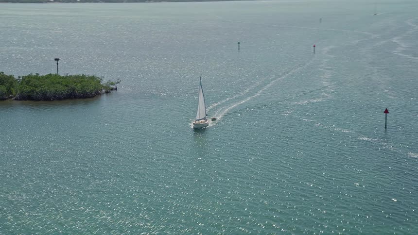A sailboat gliding through Buttonwood Sound in Key Largo Florida on a sunny day