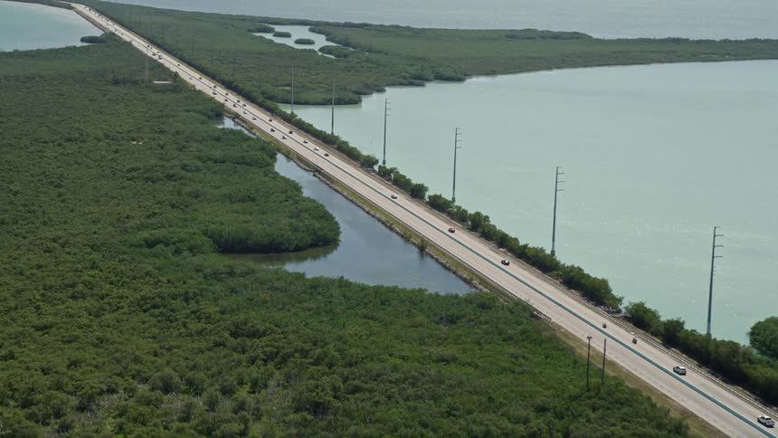 Aerial footage of traffic on a coastal highway in Key Largo Florida during the daytime