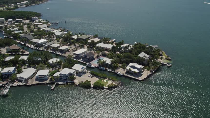 Approaching residential homes in Sexton Cove Key Largo FL captured in aerial footage during a sunny summer day