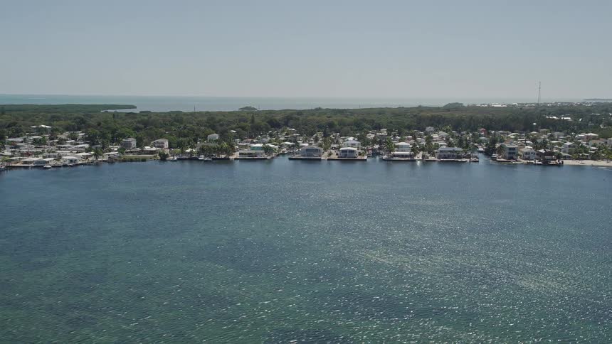 Aerial view of multiple residential homes lining the coastal area near Blackwater Sound Key Largo Florida on a sunny day