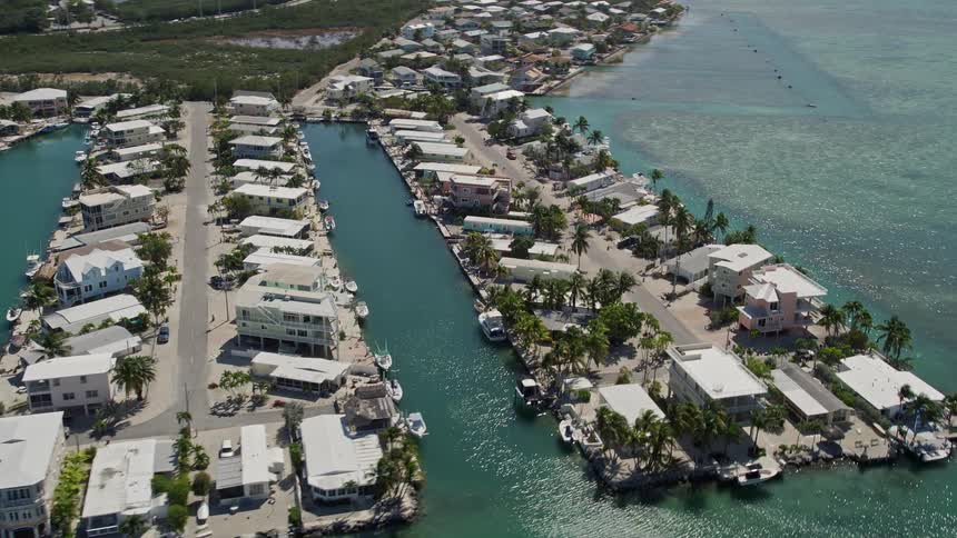Aerial view of luxurious residential neighborhoods and waterfront properties along the shoreline of Tavernier Florida on a sunny summer day