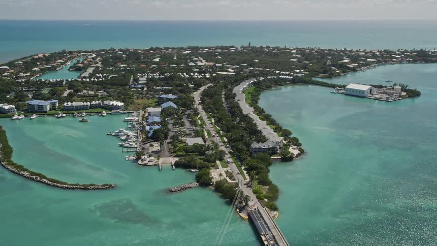 Fly by the beautiful coastal communities of Duck Key Marathon Florida on a sunny day capturing the stunning residential areas and picturesque shorelines