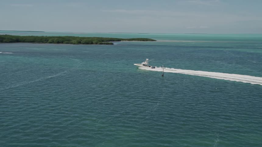 Aerial footage of a fishing boat rushing past mangroves in Tavernier Florida