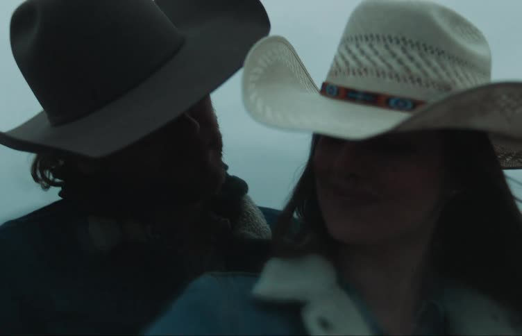 Man and woman are wearing cowboy hats outdoors