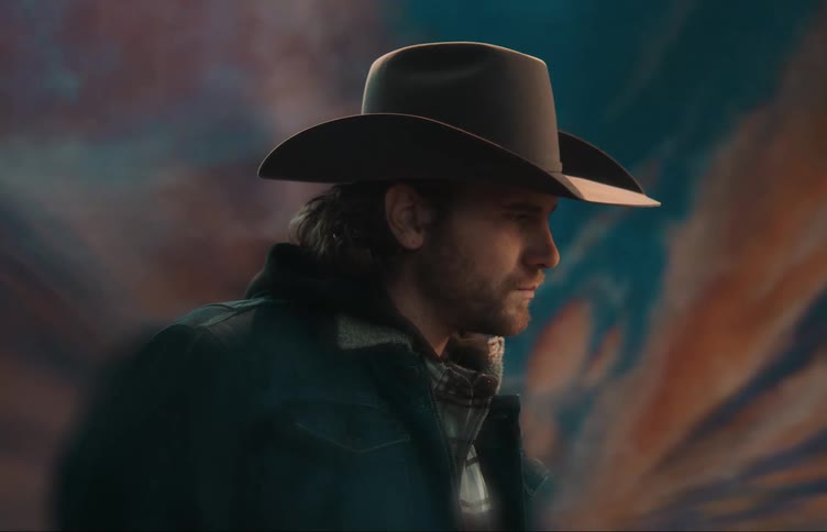 A man is standing outdoors and wearing a hat