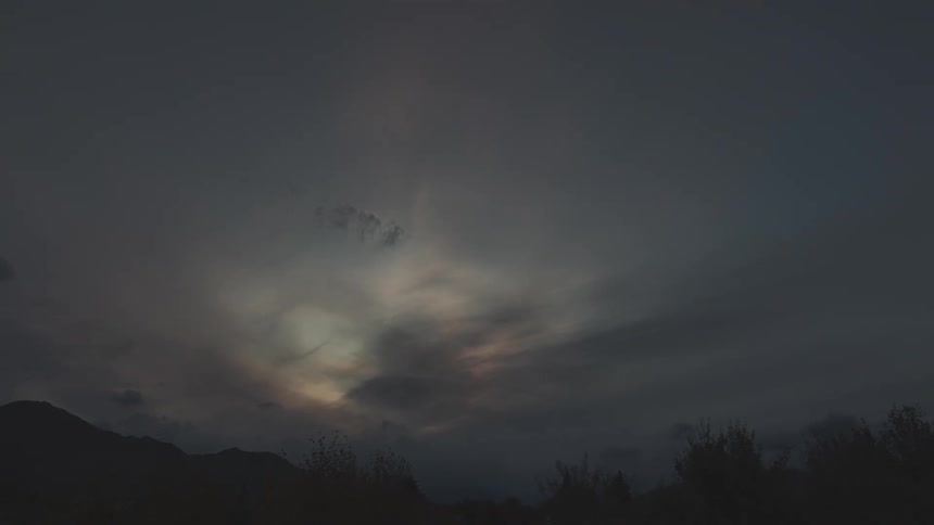 Time lapse of clouds rolling over the mountains in the countryside at nightfall