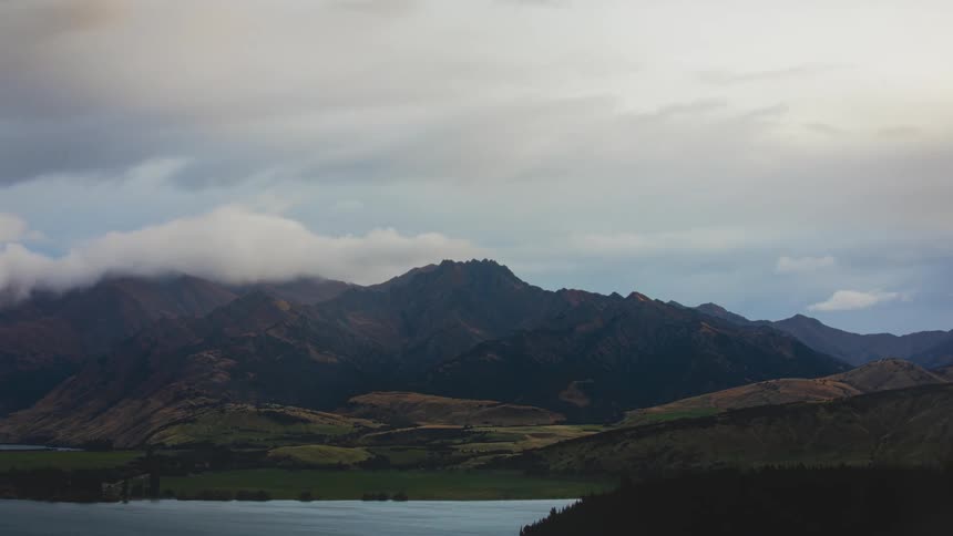 A mountain range is seen in the distance as clouds pass overhead