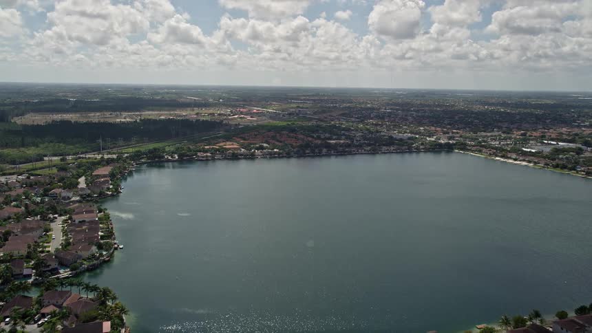 Flying over the beautiful suburb of Three Lakes in Miami Florida capturing breathtaking views of houses surrounding the serene lakefront property