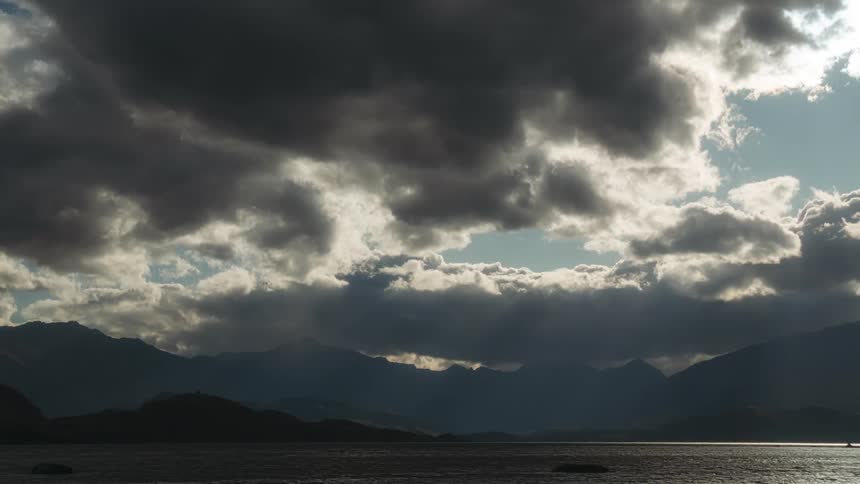 A time lapse shows clouds passing overhead above a large lake