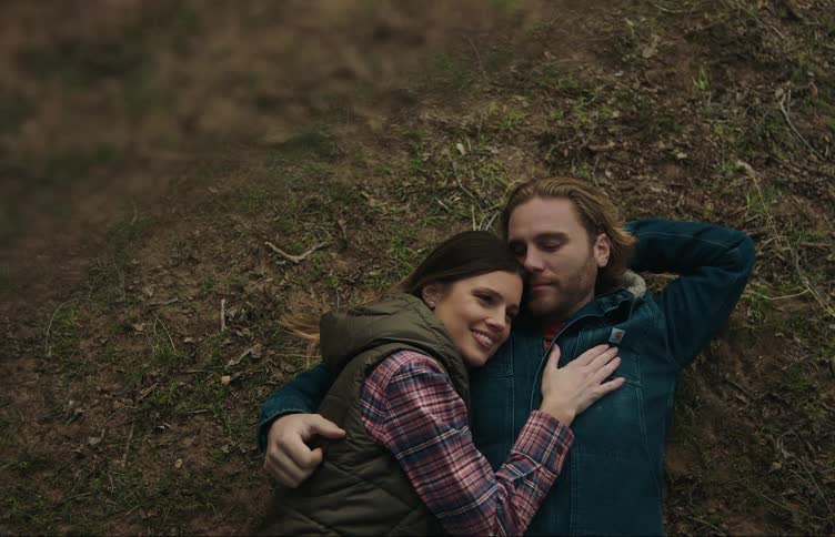 A man and woman hug on the ground