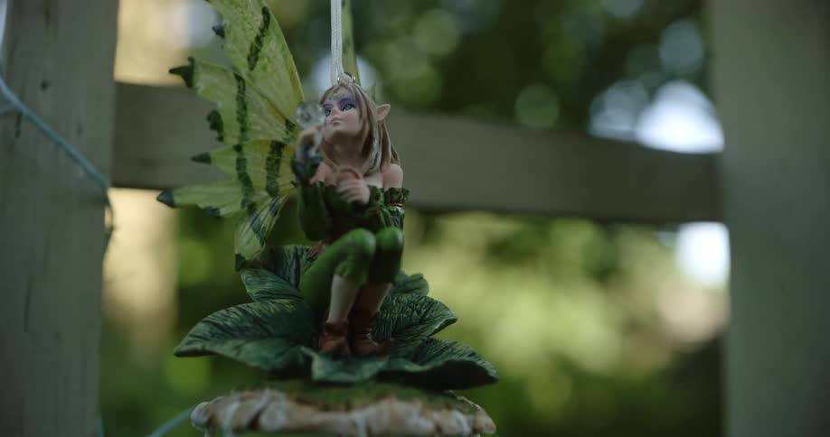 A fairy ornament hanging outside near a railing