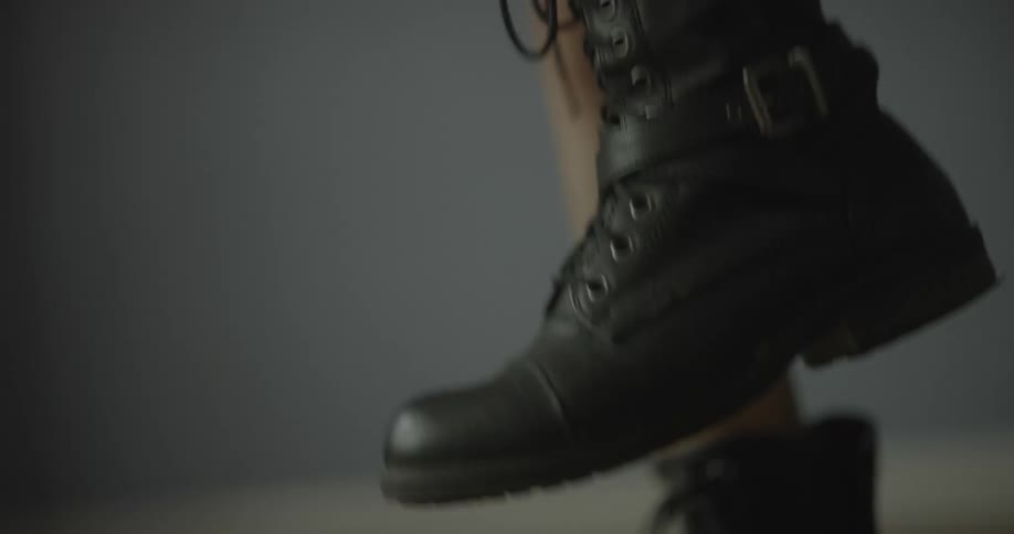 Close up of a girl excitedly wearing black leather boots
